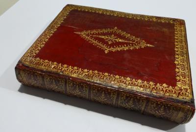 Repaired book with board reattached and corners repaired with leather